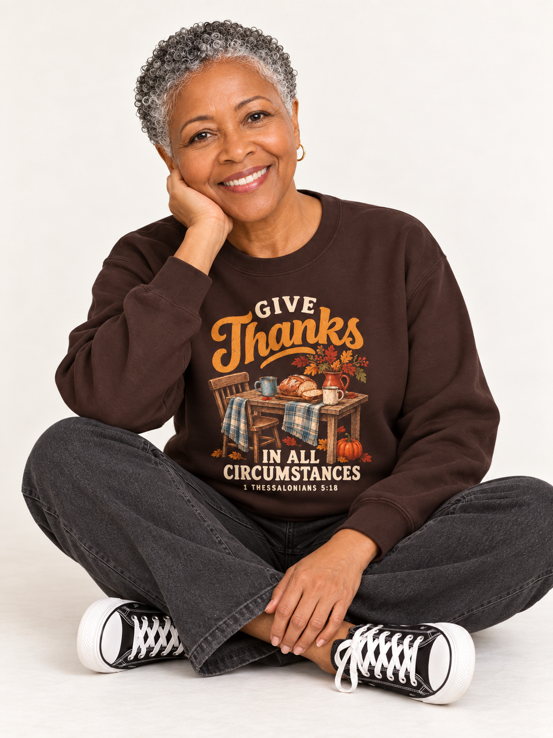 Give Thanks sweatshirt in Dark Chocolate — seated floor on a model