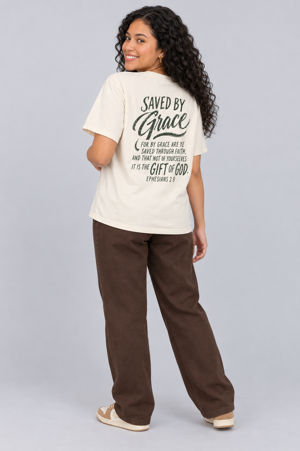 Woman wearing the Ivory Saved By Grace Tee in a shoulder-turn back pose.