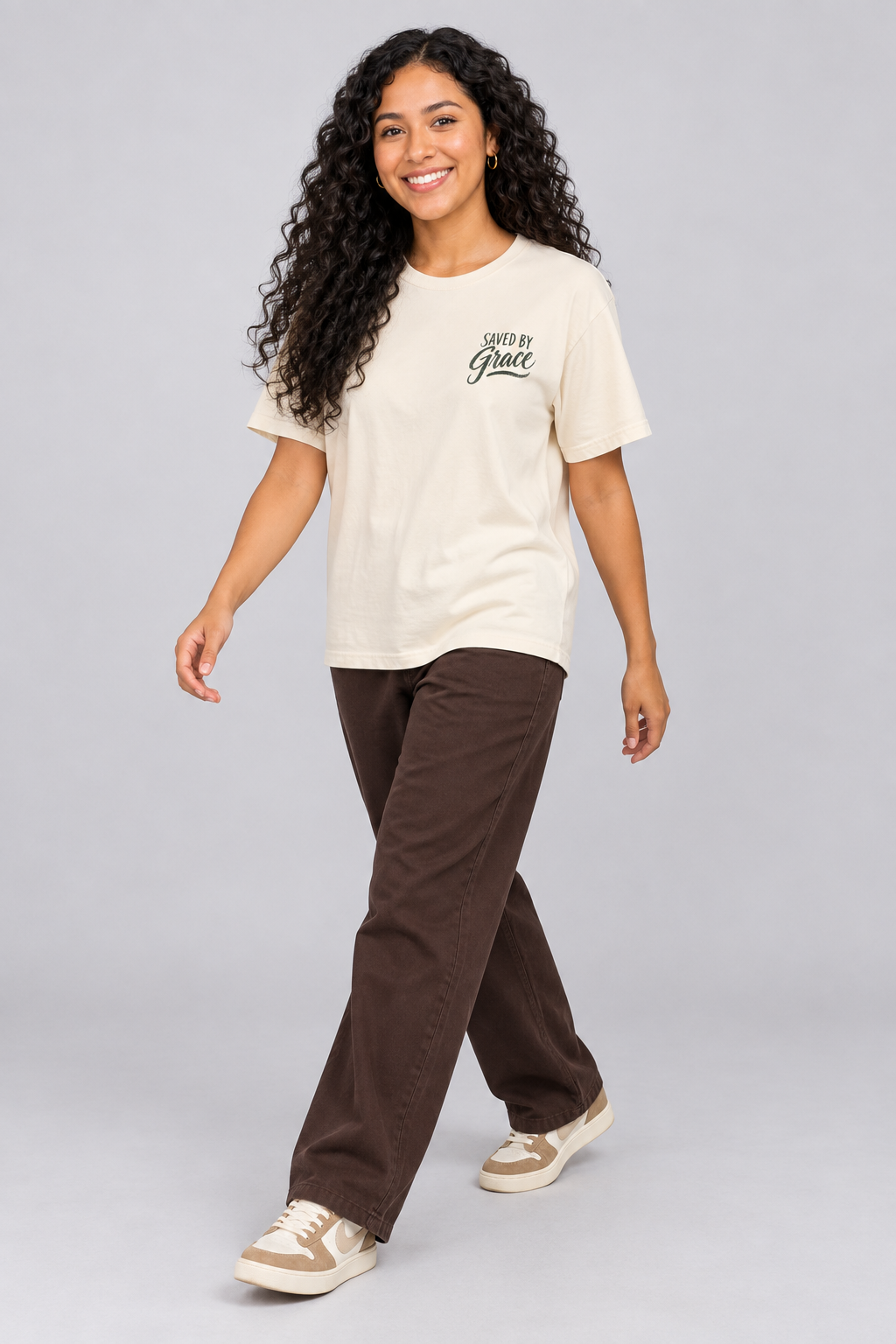 Woman wearing the Ivory Saved By Grace Tee in a walking pose.
