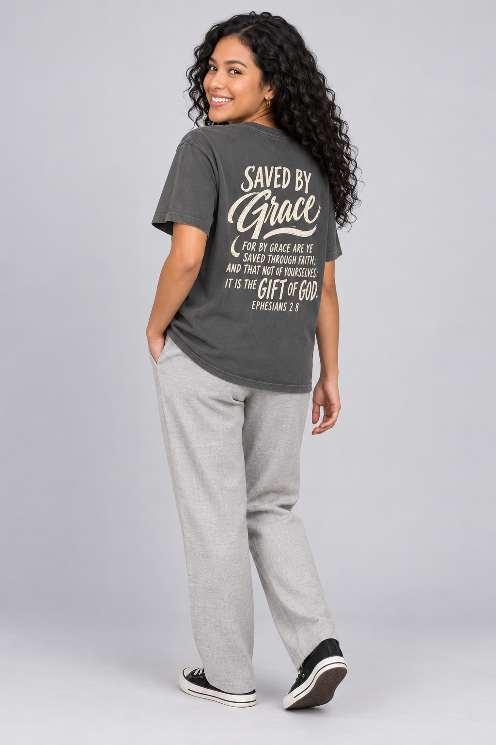 Woman wearing the Pepper Saved By Grace Tee in a shoulder-turn back pose.