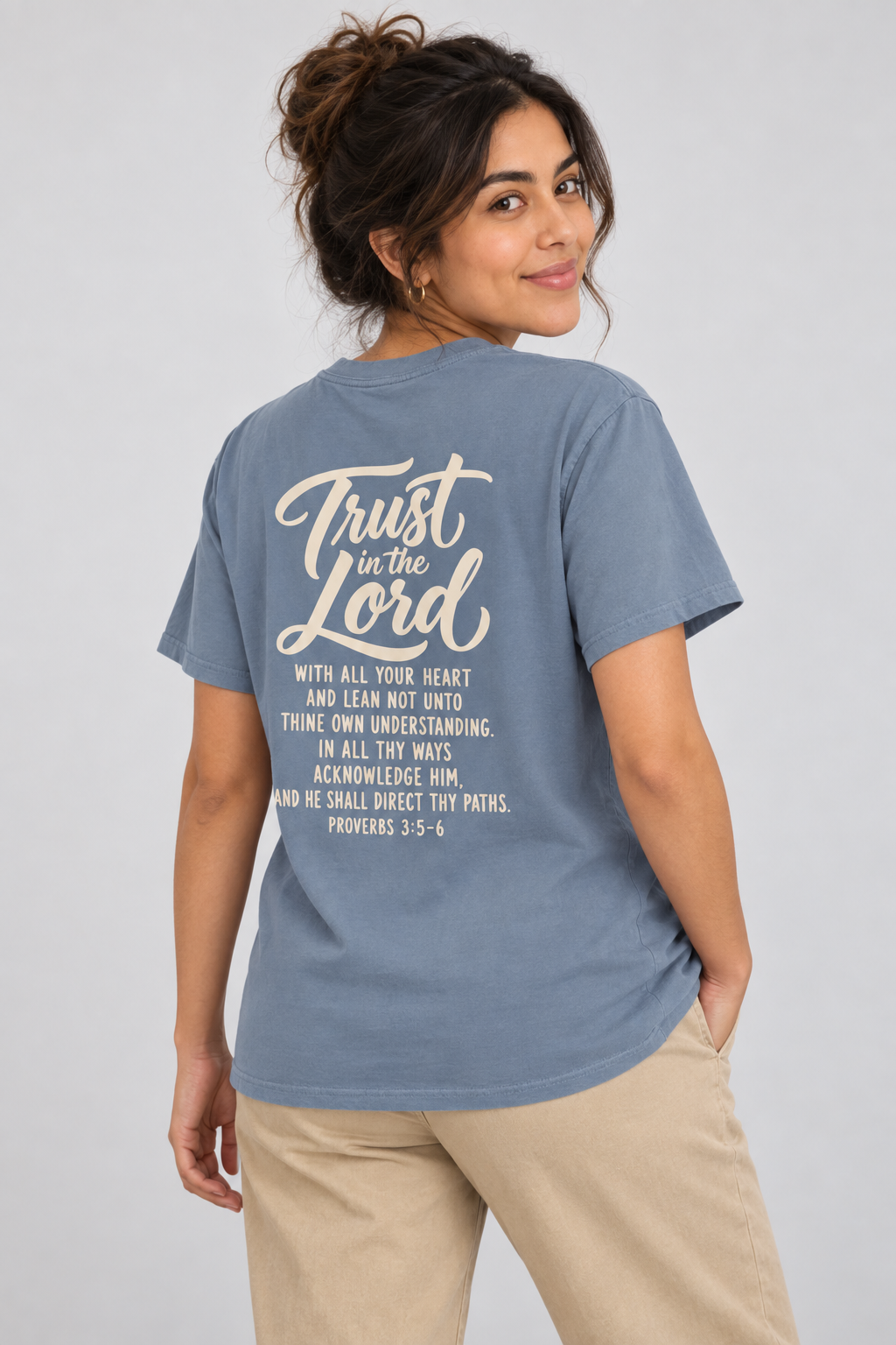 Woman wearing the Blue Jean Trust In The Lord Tee in a shoulder-turn back pose.