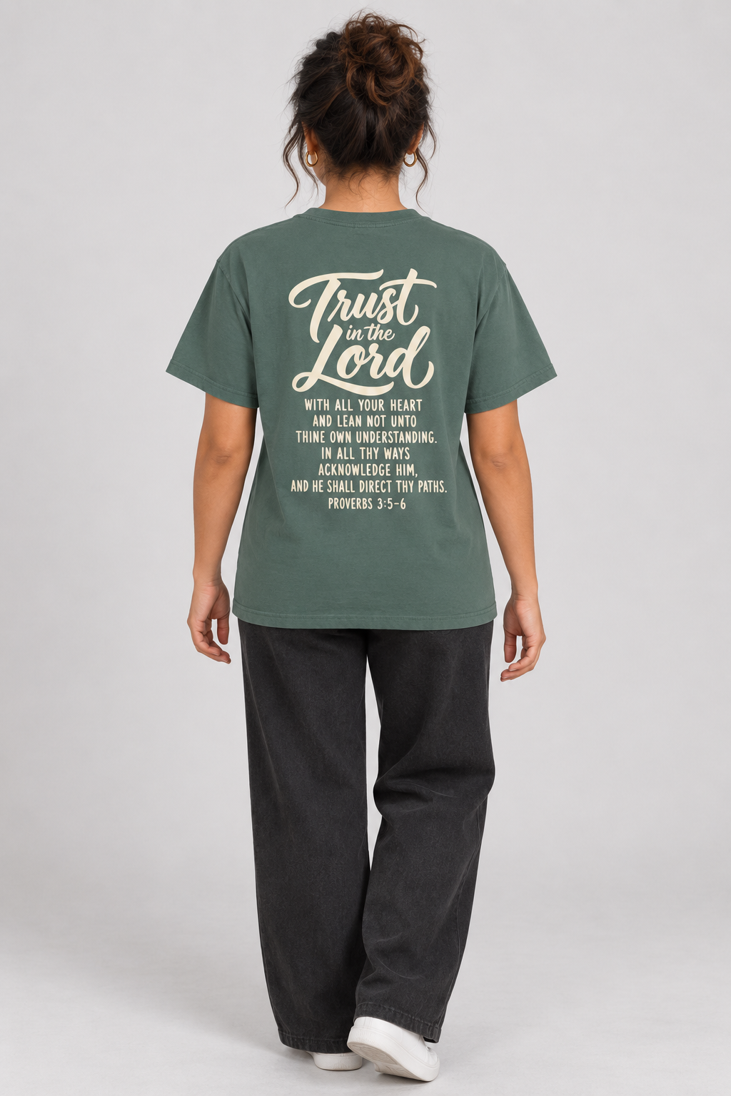 Woman wearing the Blue Spruce Trust In The Lord Tee in a full back pose.