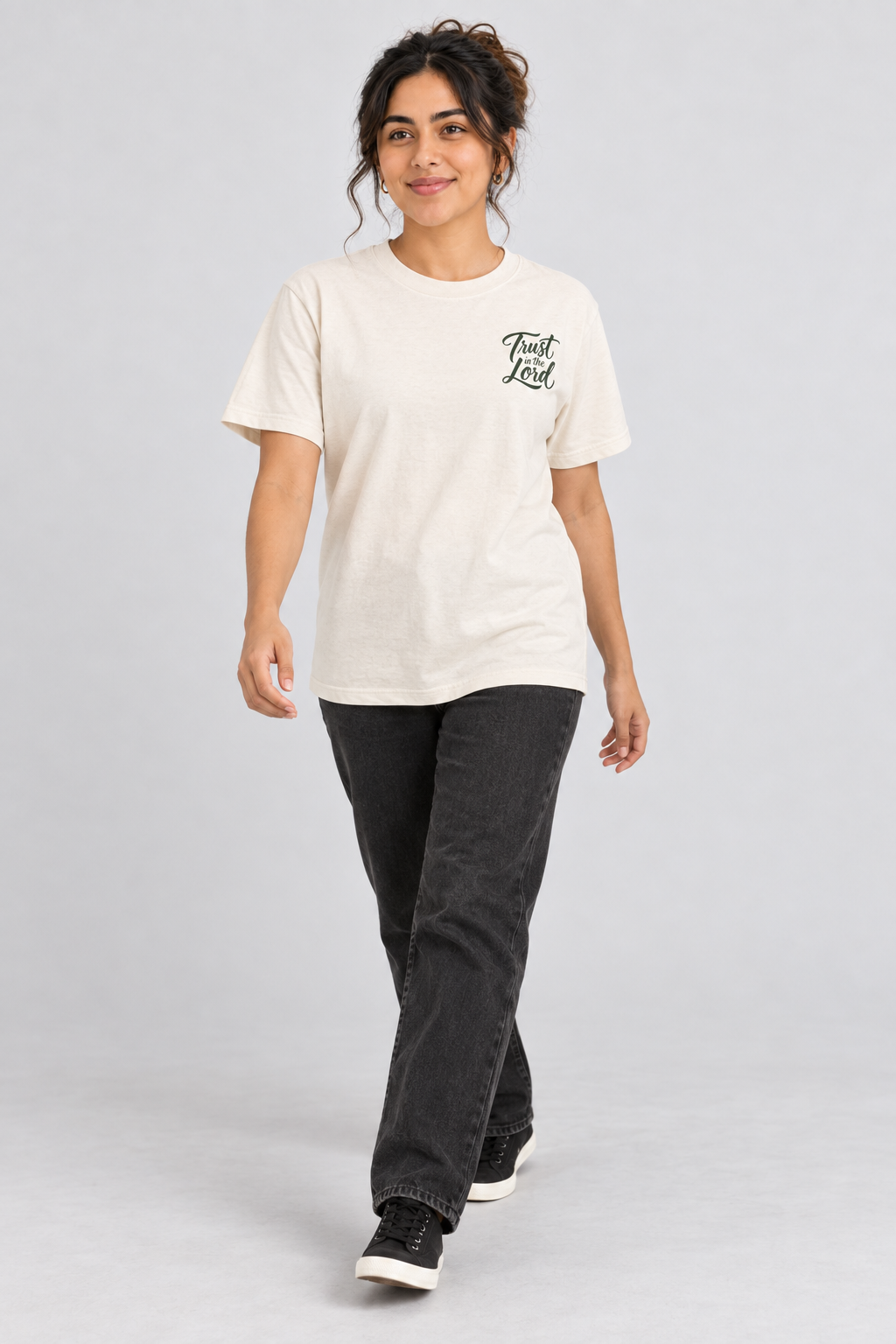 Woman wearing the Ivory Trust In The Lord Tee in a walking pose.