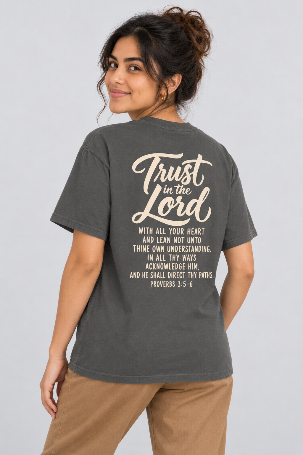 Woman wearing the Pepper Trust In The Lord Tee in a shoulder-turn back pose.