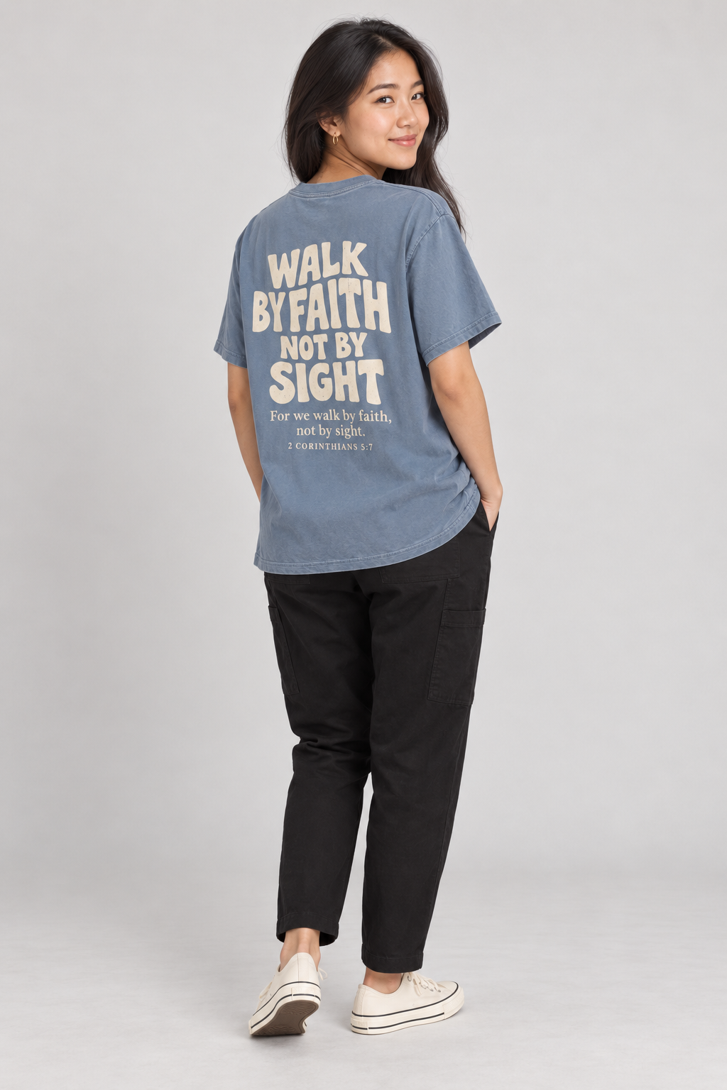 Woman wearing the Blue Jean Walk By Faith Tee in a shoulder-turn back pose.