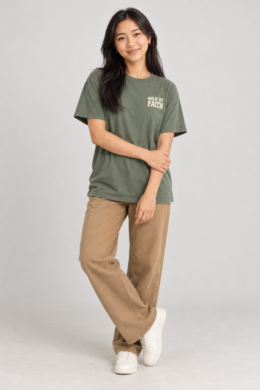 Woman wearing the Moss Walk By Faith Tee in a standing pose.