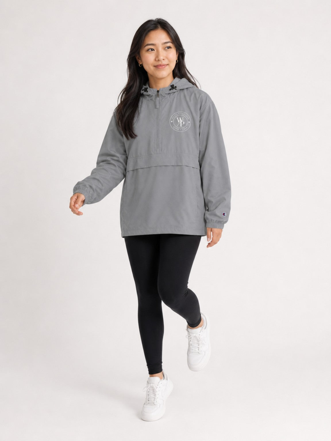 Woman wearing the graphite Worn with Purpose Champion packable anorak jacket, walking lifestyle view