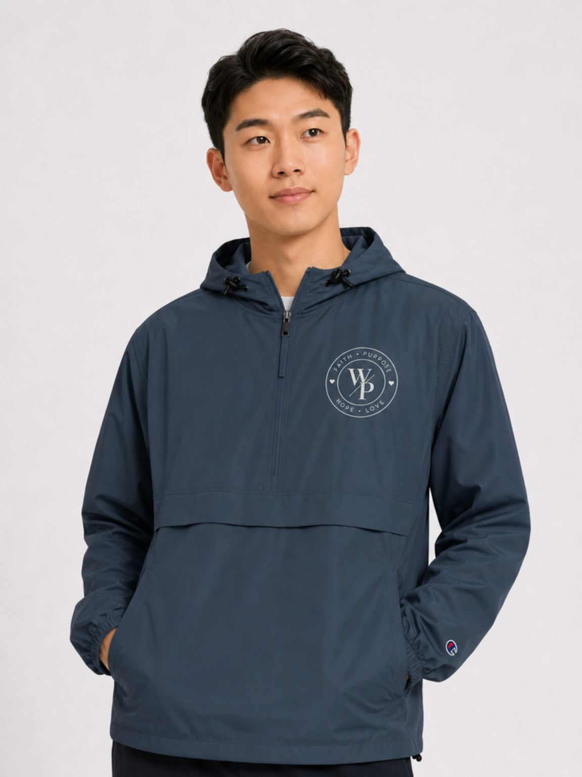 Navy Worn with Purpose Champion packable anorak jacket, close-up of embroidered WP seal
